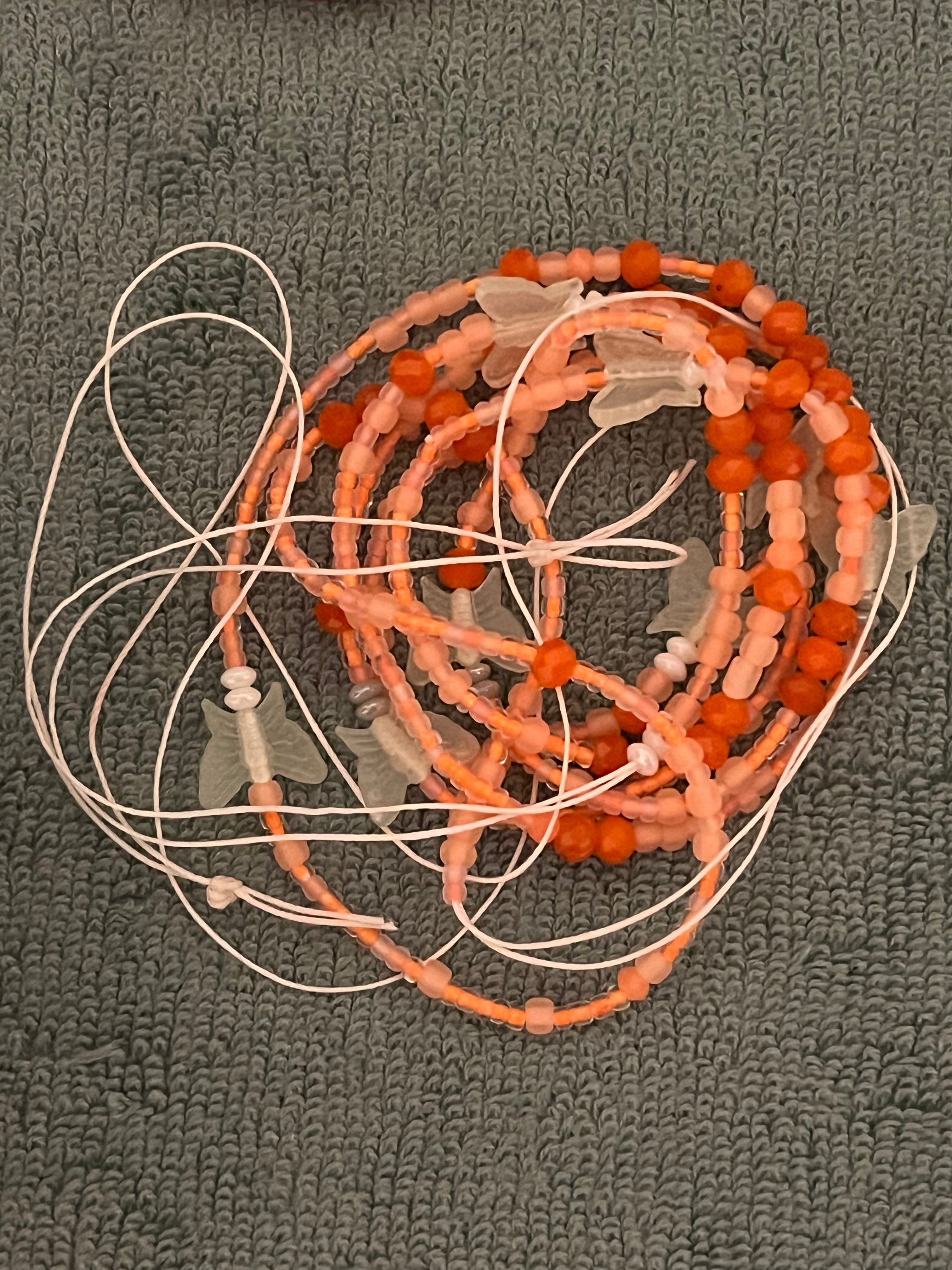Orange waist bead with glow in the dark butterflies on there 50 inches long tie on